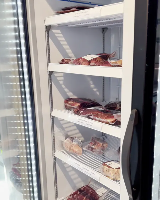 Blick in einen Kühlschrank mit abgepacktem Rindfleisch im Hofladen.